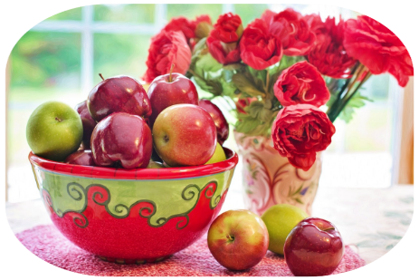Obstschale mit Äpfeln und Vase mit Rosen